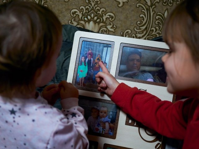 Світланка та Аліна Головчак розглядають фото батька